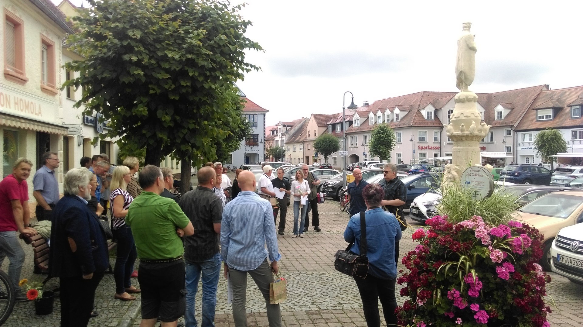 Eine Gruppe von Menschen steht auf einem Marktplatz.