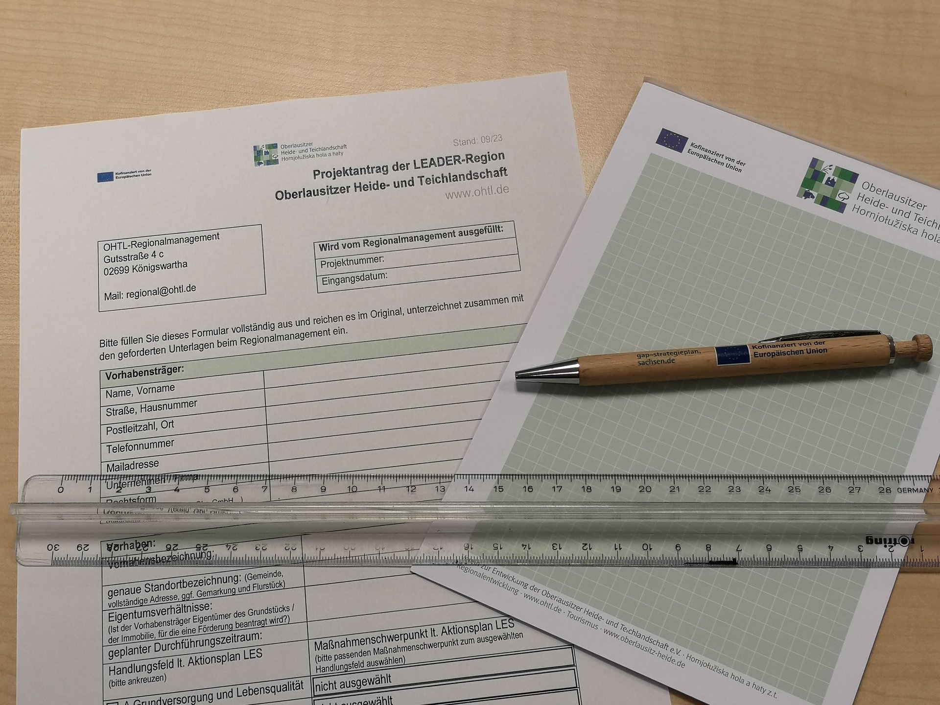 Ein Formular für ein LEADER-Projektantrag samt Stift und Notizblock.